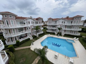 A Charming Two-Bed Apartment In Belek For Sale - A central communal pool and terraces surrounded by gardens