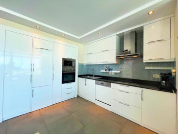 A Sea & Nature View Alanya Duplex Apartment For Sale In Kargicak - A fully fitted kitchen with built-in white goods