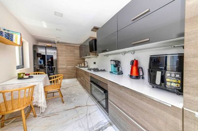 Exceptionally Renovated Bodrum Property For Sale - A modern, fitted kitchen featuring built-in appliances and ample storage and worktop space